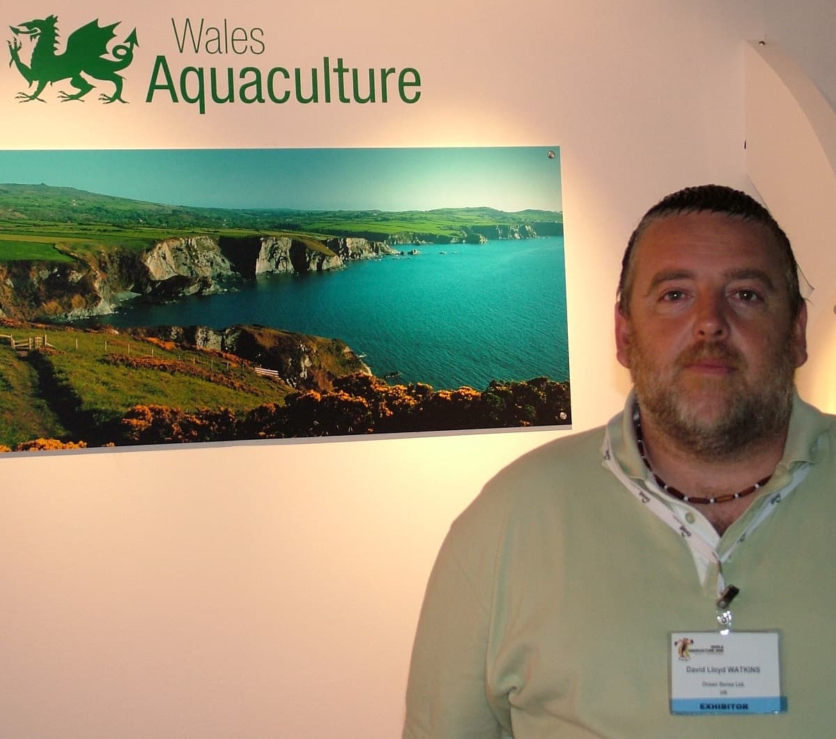 Lloyd Watkins has brought the carbon neutral restaurant commitment to Tenkaichi, here he is at the World Aquaculture Show, with an image of the Welsh Coastline and the words Wales Aquaculture behind him